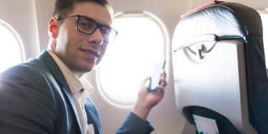 man on airplane using his phone